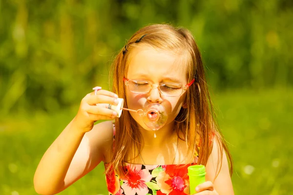 Little girl blowing soap bubbles — Stock Photo, Image