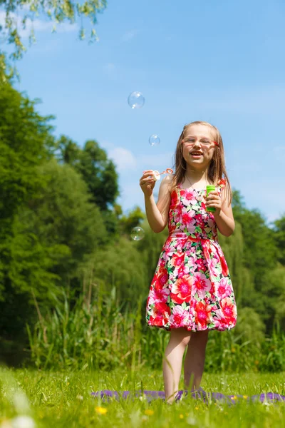 Little girl blowing soap bubbles — Stock Photo, Image