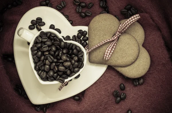 Кофейные зерна в форме сердца чашки и десерт — стоковое фото