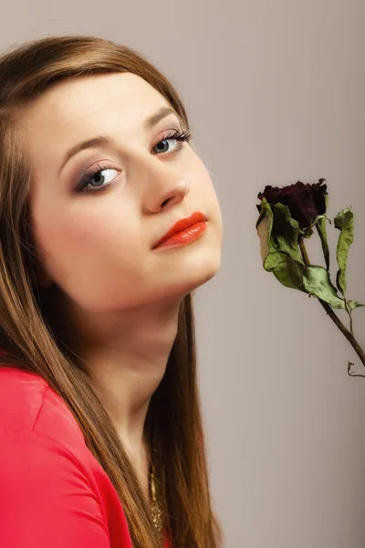 Vrouw in rode jurk poseren met droge rose. — Stockfoto