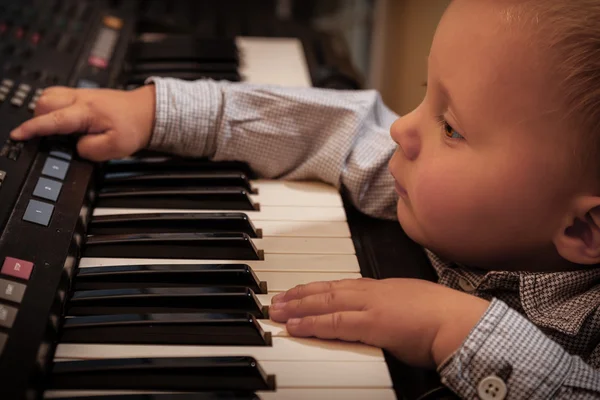 Menino tocando no sintetizador de piano de teclado digital — Fotografia de Stock