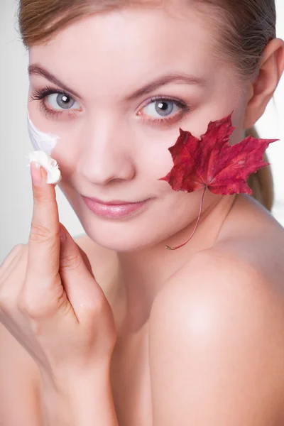 Skin care. Face of young woman girl with red maple leaf. — Stock Photo, Image