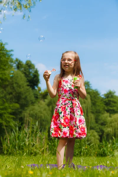 Little girl blowing soap bubbles — Stock Photo, Image