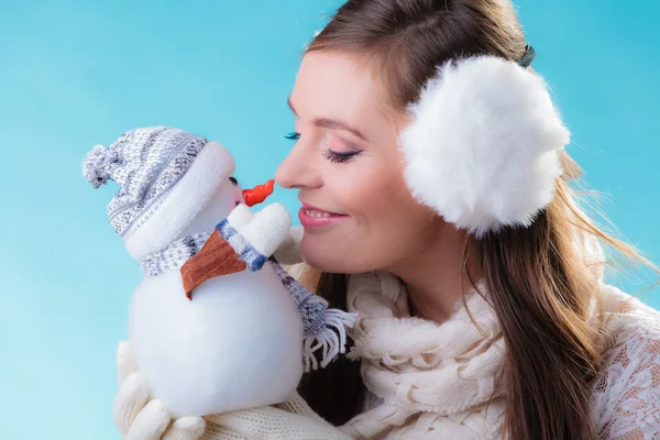 Woman in warm clothes holding snowman toy. — Stock Photo, Image