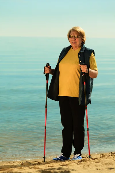 Seniorin spaziert am Strand — Stockfoto