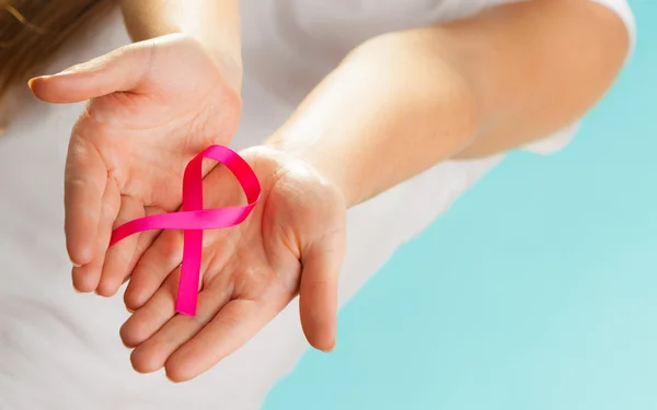 Nastro rosa di consapevolezza del cancro al seno sulle mani delle donne — Foto Stock