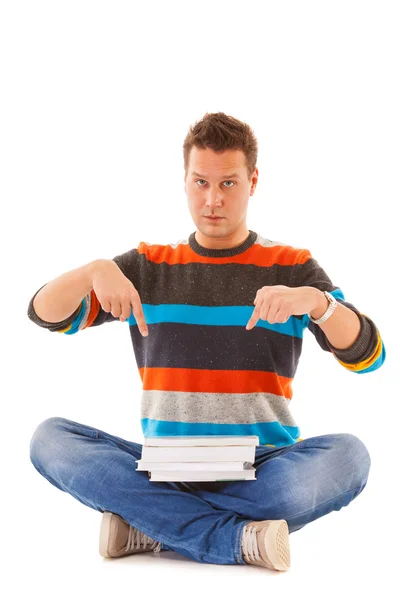 Hombre estudiante universitario sentado y mostrando ofreciendo libros aislados —  Fotos de Stock