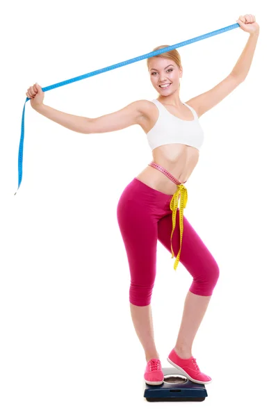 Girl with measure tape on weight scale — Stock Photo, Image