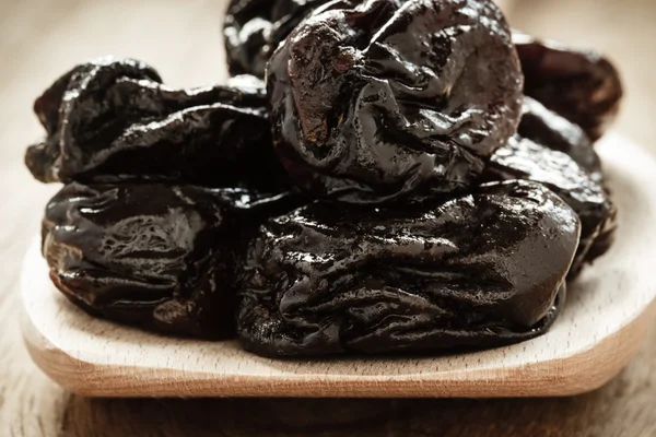 Prunes on wooden spoon — Stock Photo, Image