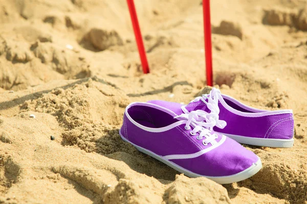 Nordic Walking. Stöcke und violette Schuhe an einem Sandstrand — Stockfoto