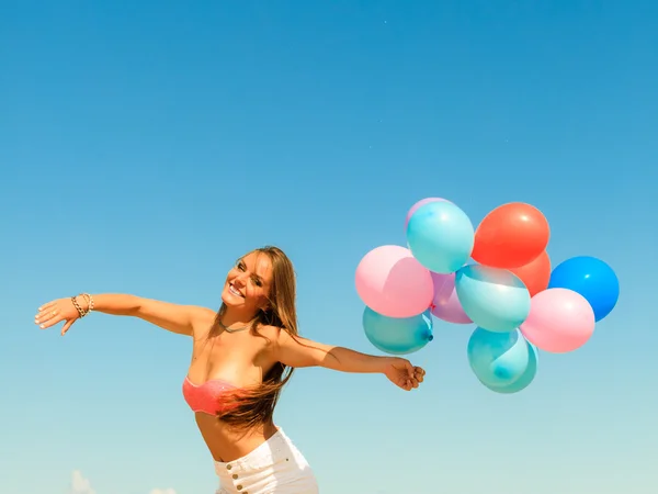 Flickan hoppar med färgglada ballonger — Stockfoto