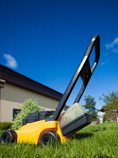 黄色の芝刈り機の芝生を刈る — ストック写真