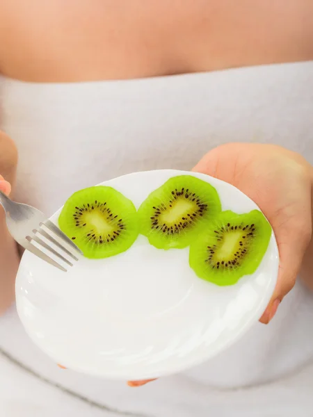 Girl eating slices of kiwi — Stock Photo, Image