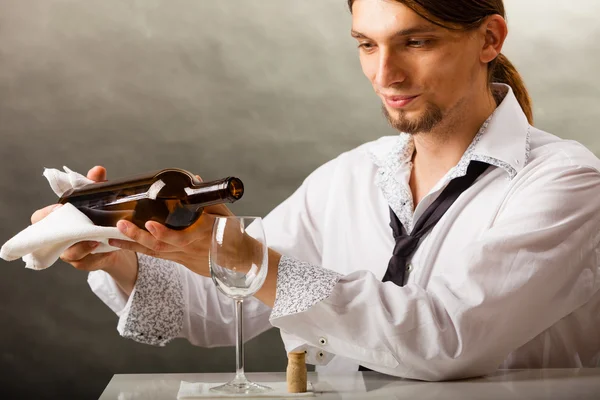 Человек официант разливает вино — стоковое фото