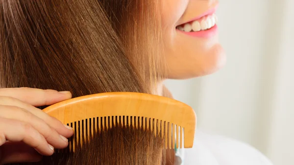 Peinando su largo cabello castaño — Foto de Stock