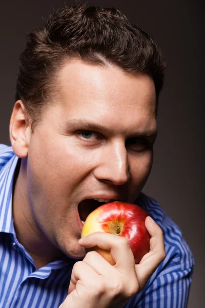 Hombre mordiendo manzana — Foto de Stock