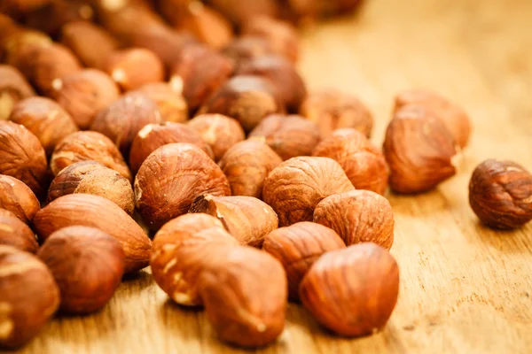 Hazelnuts on rustic old wooden table — Stock Photo, Image