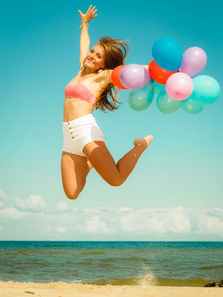 Flicka hoppar med ballonger — Stockfoto