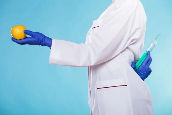 Hand holding fruit and syginge. — Stock Photo, Image