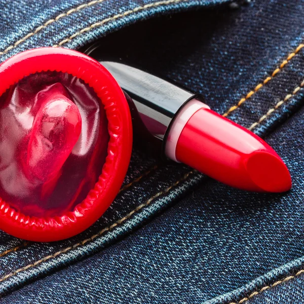 Condom and lipstick on jeans pocket. — Stock Photo, Image