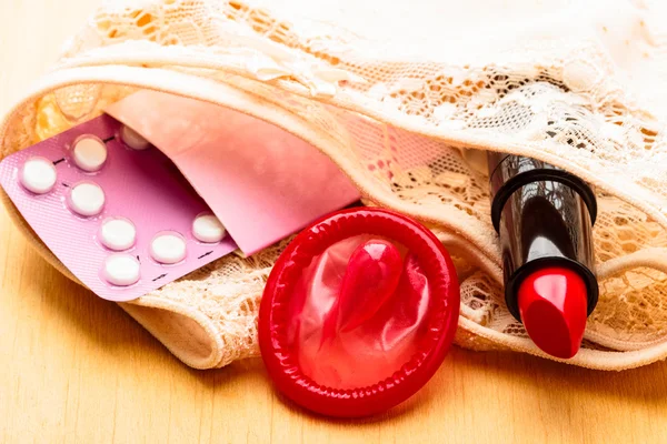 Pills, condom and lipstick — Stock Photo, Image