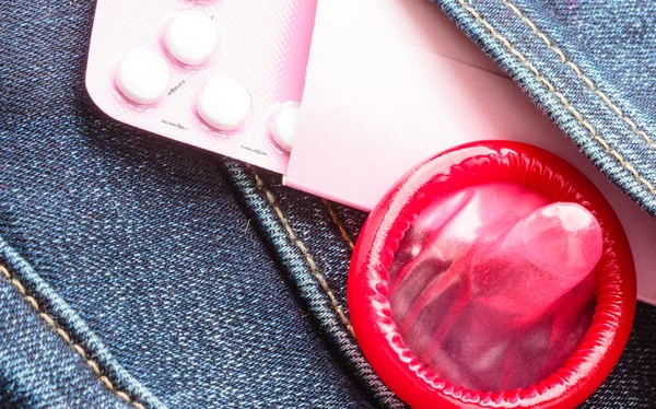 Tabletki i prezerwatywy w kieszeni. — Zdjęcie stockowe