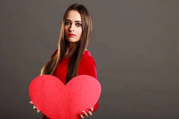 Chica sosteniendo corazón rojo signo de amor —  Fotos de Stock