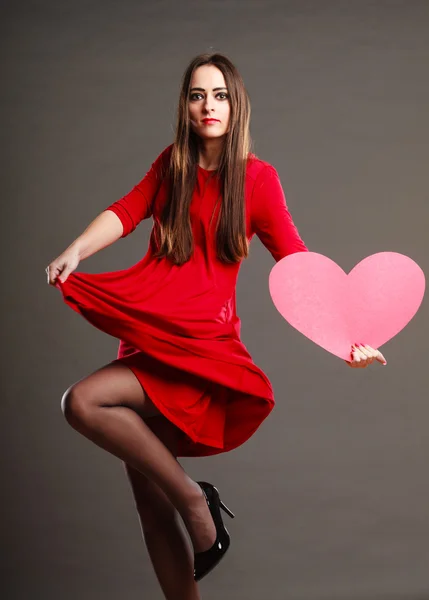 Donna in abito rosso tiene il segno del cuore — Foto Stock