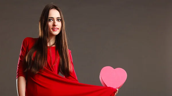 Femme robe rouge tient boîte en forme de coeur — Photo