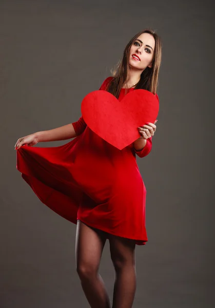 Mulher de vestido vermelho segurando coração — Fotografia de Stock