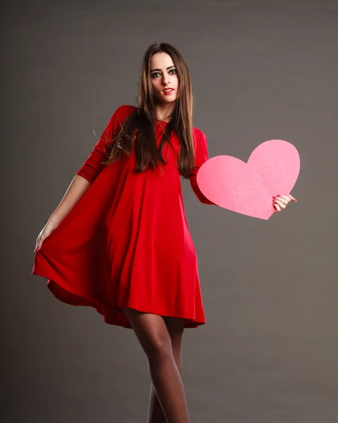 Femme en robe rouge tenant coeur — Photo