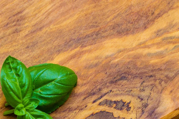 Foglie di basilico sul tavolo di legno — Foto Stock