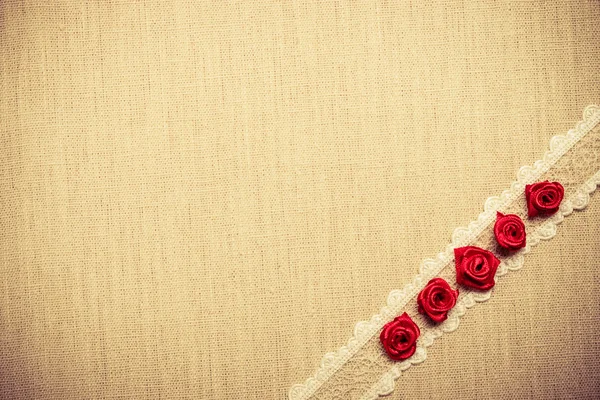 Рамка из красных шелковых роз на ткани — стоковое фото