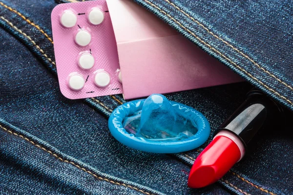 Pills, condom and red lipstick — Stock Photo, Image