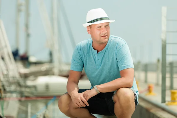 Mann sitzt auf Seebrücke gegen Yachten — Stockfoto