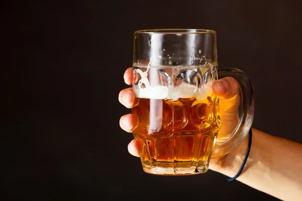 Male hand holding mug of beer — Stock Photo, Image