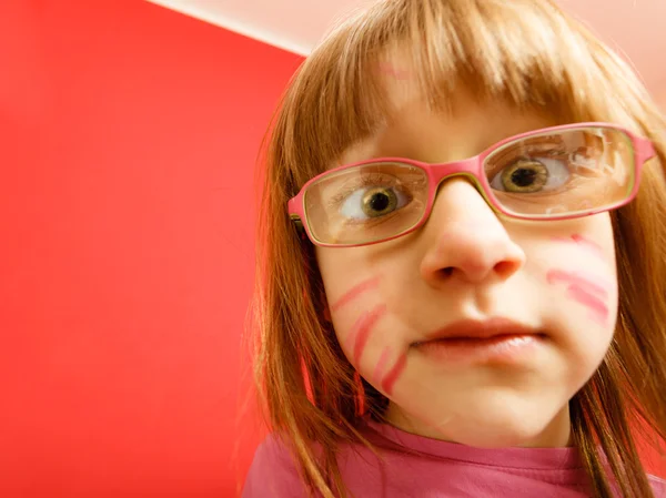 Fille dans des lunettes avec peint drôle visage — Photo