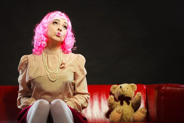 Childlike woman sitting on couch — Stock Photo, Image