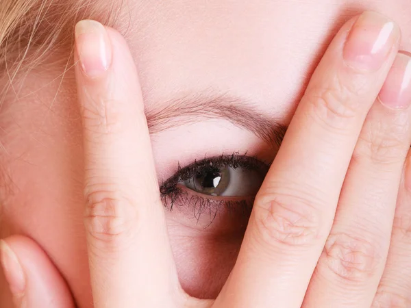 Mujer mirando a través de los dedos . — Foto de Stock