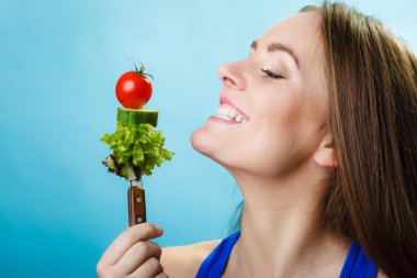 Girl holding fork with vegetables clipart