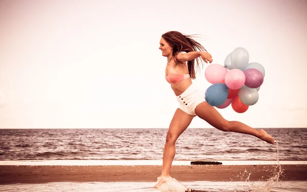 Chica saltando con globos — Foto de Stock