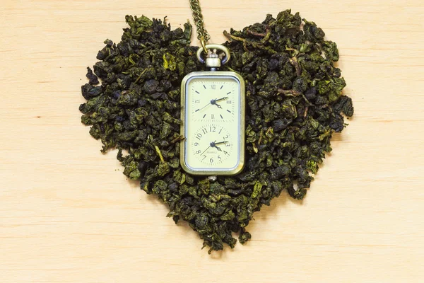 Hojas de té verde y reloj — Foto de Stock