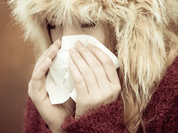 Sick woman sneezing in tissue — Stock Photo, Image