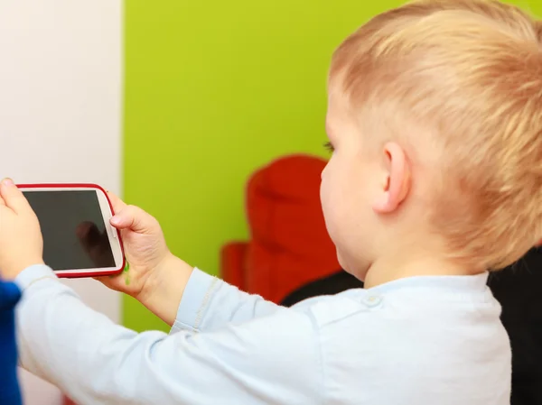 Kind spelen op mobiele telefoon. — Stockfoto