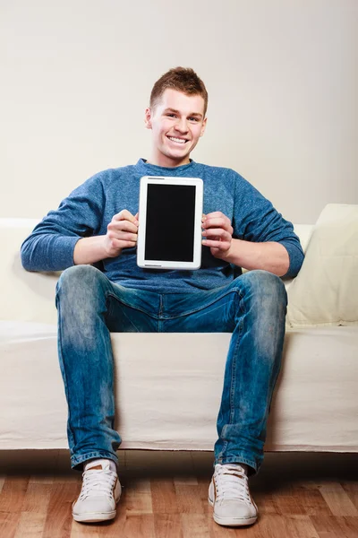 Adam kanepede oturan tablet ile — Stok fotoğraf