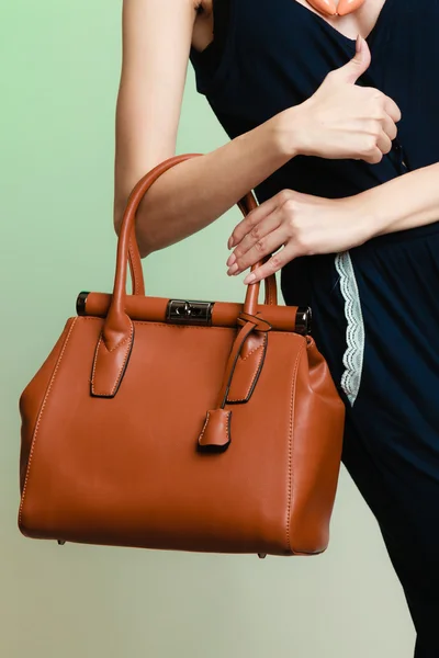 Femme élégante tenant sac à main brun — Photo
