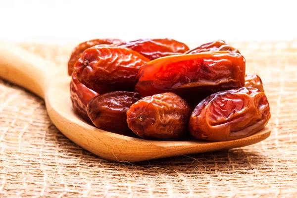 Dried dates on wooden spoon cloth background — Stock Photo, Image