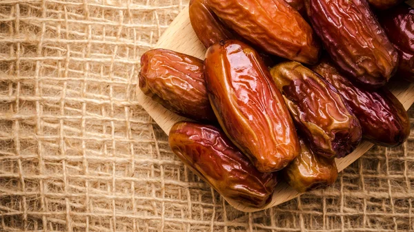 Dried dates on wooden spoon cloth background — Stock Photo, Image