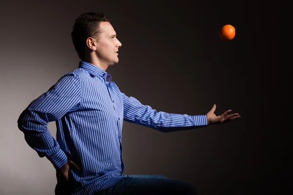 Man throwing orange — Stock Photo, Image