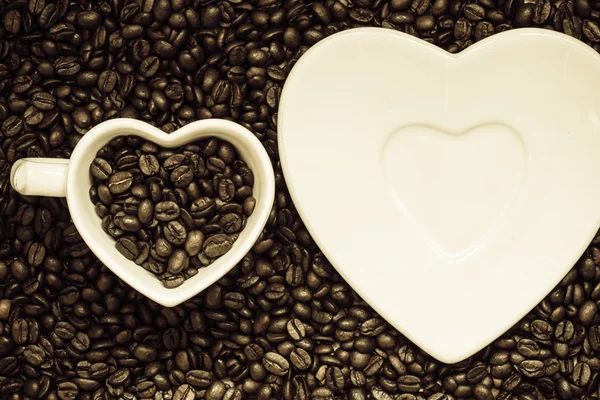 Tasse und Untertasse auf Kaffeebohnen — Stockfoto